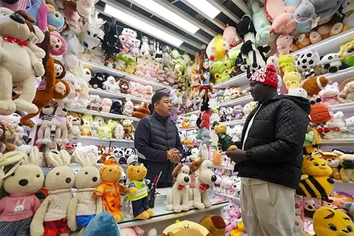 Foreign buyers and Yiwu suppliers negotiating plush toy deals